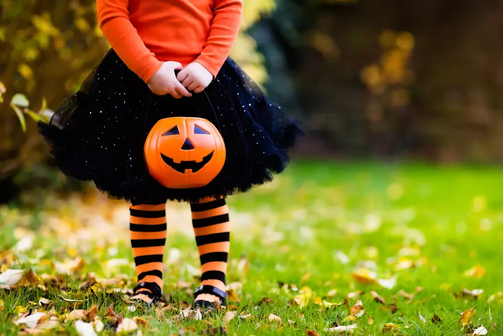 young girl dressed as witch holding pumpkin in Gatlinburg Tn