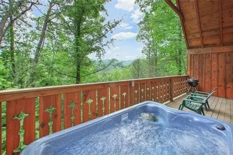 Hot tub on porch and mountains and trees in the view